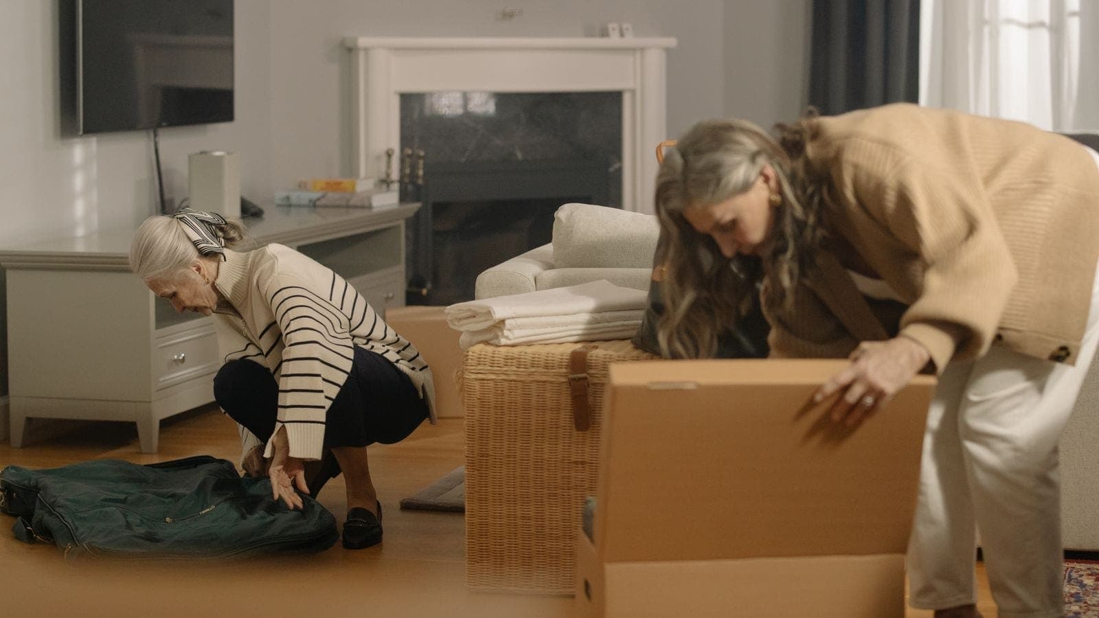 Older couple reviewing moving boxes with a professional mover in a sunlit Denver living room
